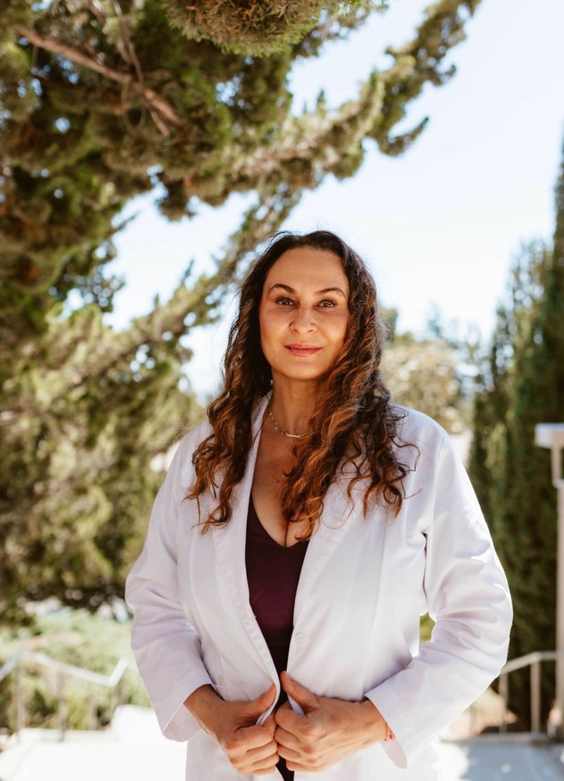 Ana, registered nurse and founder of AmoureSkin, wearing a white coat outdoors